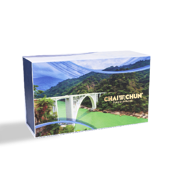 A gift box of Chai Chun tea featuring an image of a serene tea plantation with a bridge and mountains in the background.
