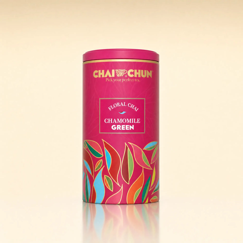 A cylindrical pink tea tin labeled CHAI CHUN Floral Chay Chamomile Green, featuring colorful stylized leaf illustrations on a warm cream background.