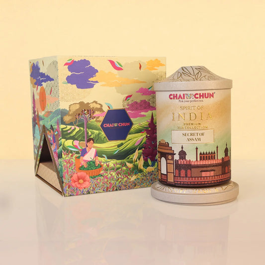 SECRET-OF-ASSAM - Chai Chun Tea Products Spirit of India Premium Tea Collection Secret for Ngiri, shown with its colorful illustrated packaging box and the cylindrical metal tin container on a light beige background.