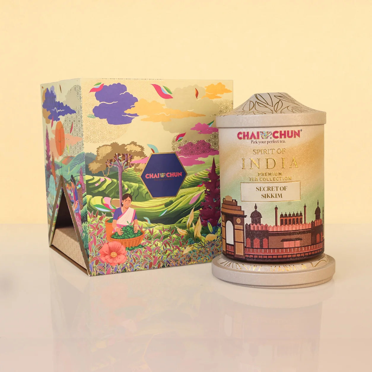 SECRET-OF-SIKKIM - ChaiChun Tea Products Spirit of India Premium Tea Collection Secret for Ngiri, shown with its colorful illustrated packaging box and the cylindrical metal tin container on a light beige background.