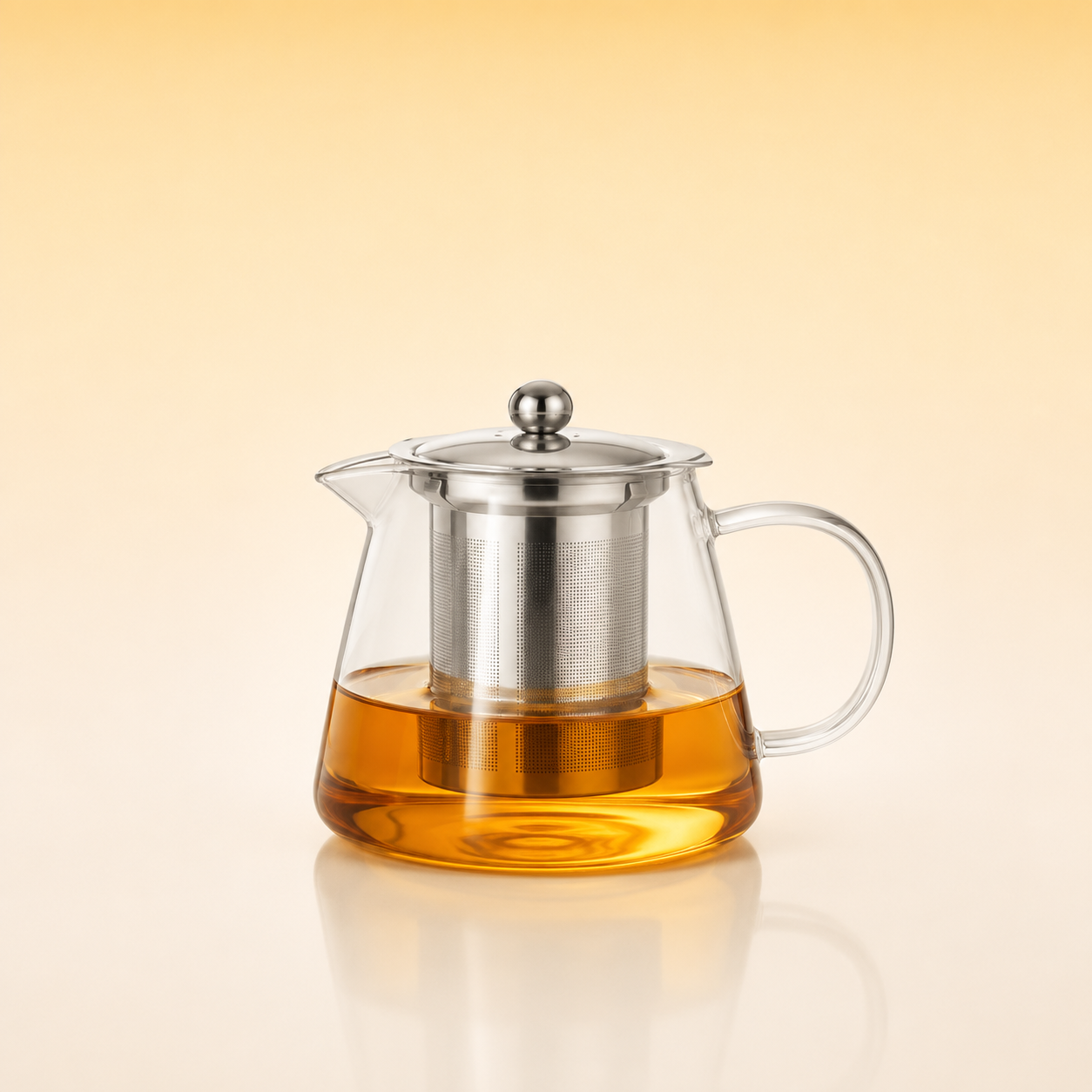 Tea Artisan Pot 450 - A clear glass teapot with a stainless steel infuser and lid, filled with amber tea, set against a warm beige gradient background.