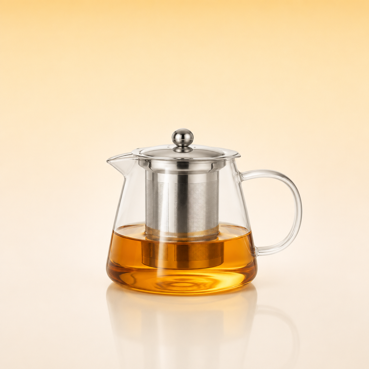 Tea Artisan Pot 550 - A clear glass teapot with a stainless steel infuser and lid, filled with amber tea, set against a warm beige gradient background.