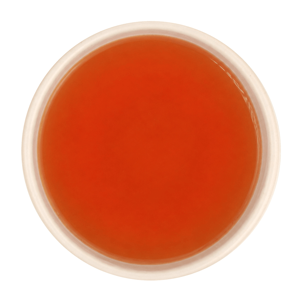 Freshly brewed Tulsi Adrak tea showing a bright, clear amber-brown liquor beautifully.