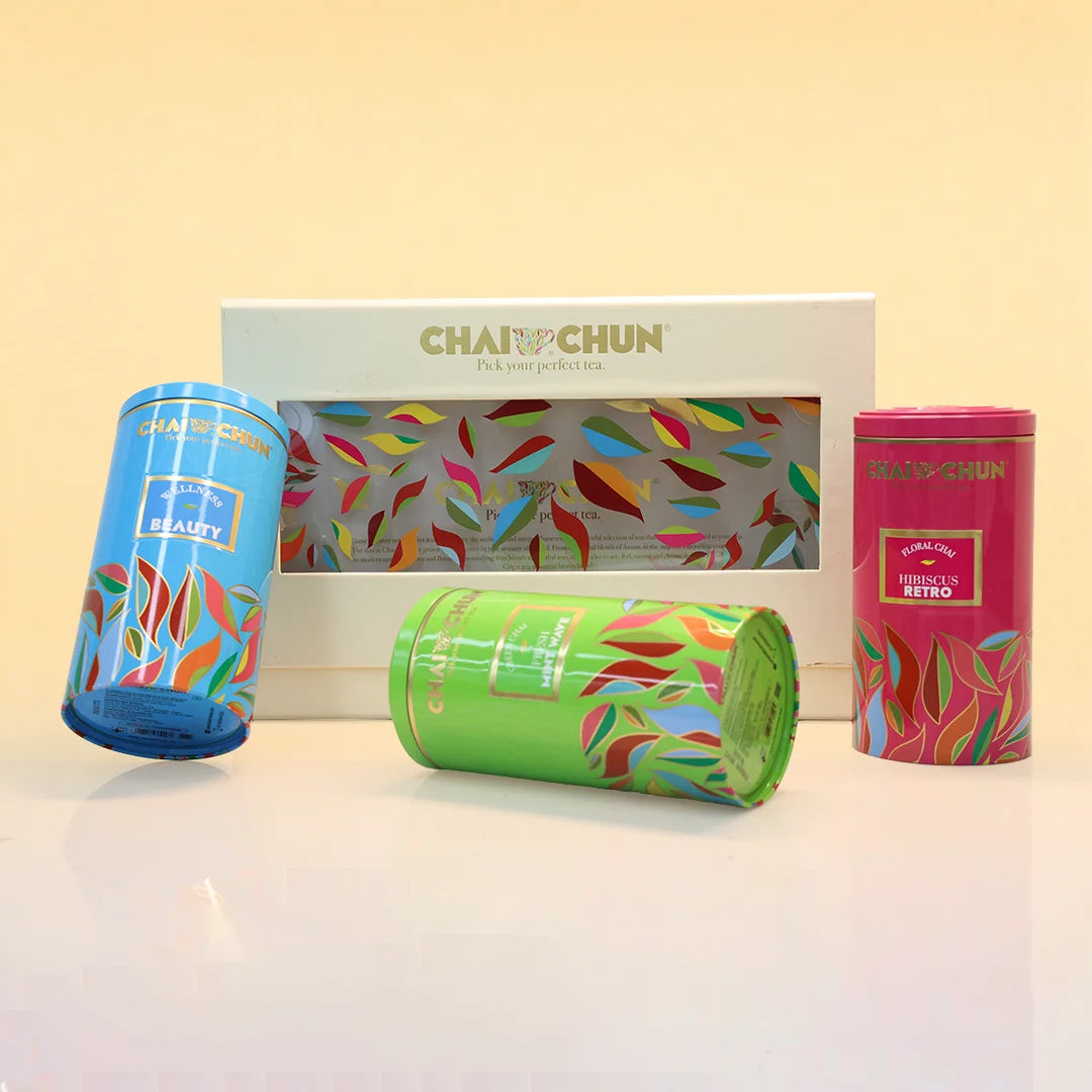 A ChaiChun tea gift set featuring three colorful cylindrical metal tea tins and a white box with a window, decorated with multicolored leaf patterns. The tins include blue, green, and pink designs, with labels for 'ChaiChun Beauty', 'ChaiChun Masala & Retro', and 'ChaiChun Classic'.