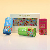A ChaiChun tea gift set featuring three colorful cylindrical metal tea tins and a white box with a window, decorated with multicolored leaf patterns. The tins include blue, green, and pink designs, with labels for 'ChaiChun Beauty', 'ChaiChun Masala & Retro', and 'ChaiChun Classic'.